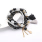 Lovra bracelet laid flat showing full length of beaded strands and tassel pendant