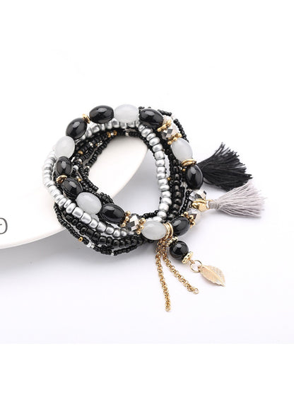 Lovra bracelet laid flat showing full length of beaded strands and tassel pendant