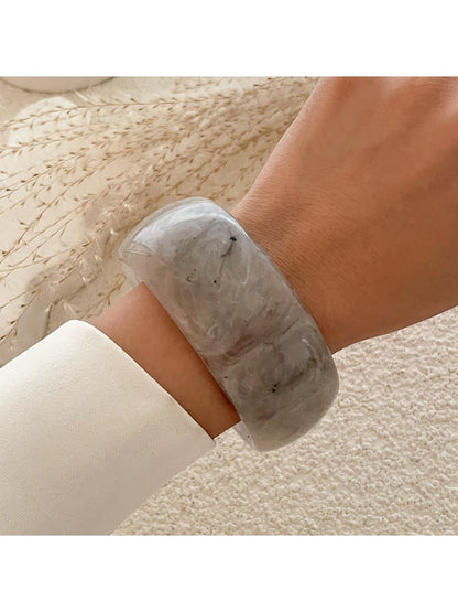 Lovra round bangle bracelet displayed on a jewelry stand with soft lighting