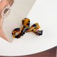 Beau delicate bow hair claw clip with smooth matte texture close-up