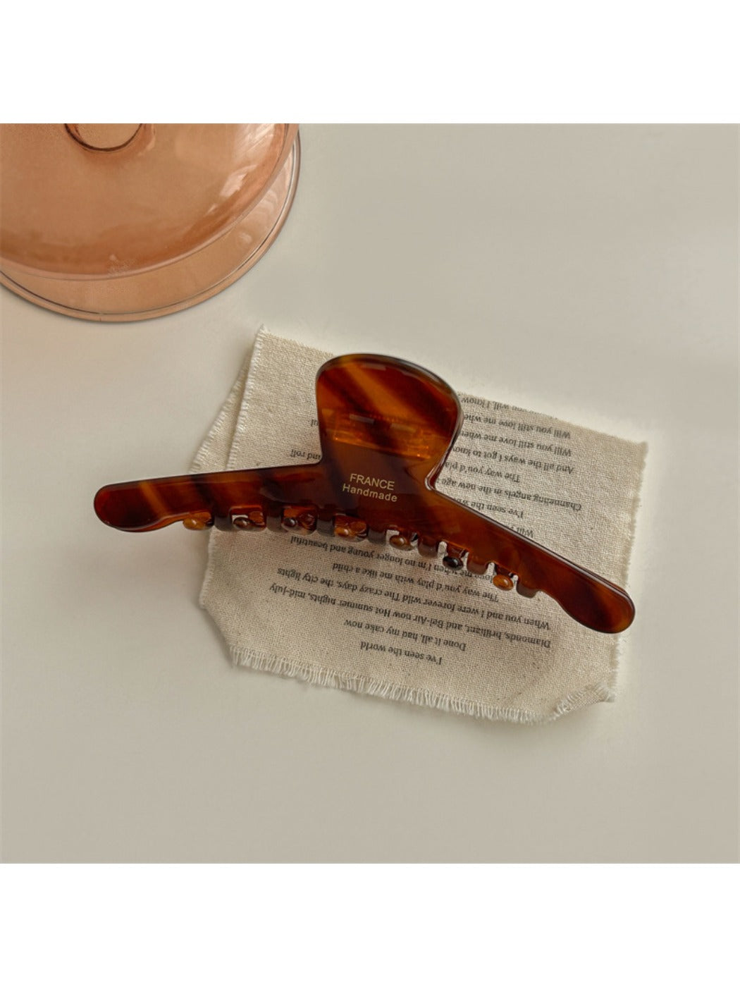 Beau chic acetate claw clip photographed with soft shadows on a neutral background