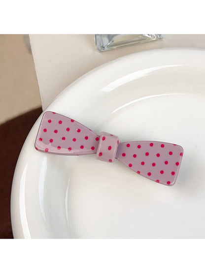 Beau sweet pink hair claw clip with white polka dots against a pastel background