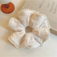Close-up of beige ruffle scrunchie showing texture and fabric folds