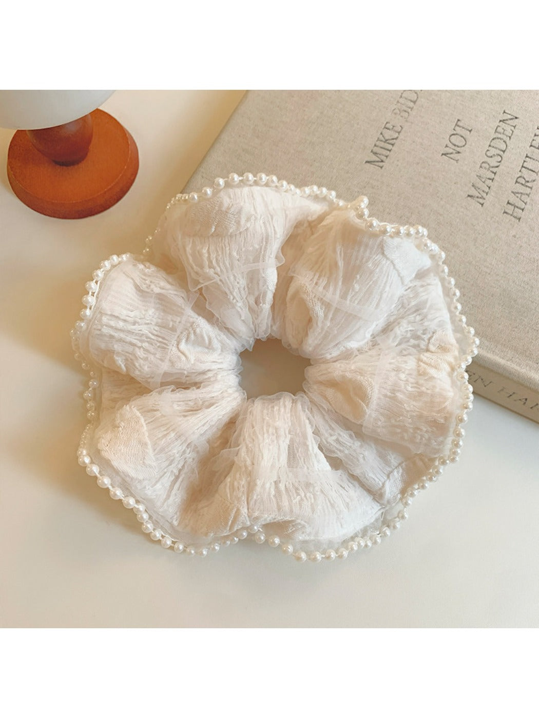 Close-up of beige ruffle scrunchie showing texture and fabric folds