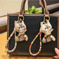 Vintage cat charm keychain with intricate engraved details on metal surface
