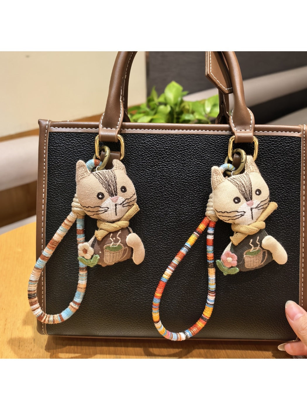 Vintage cat charm keychain with intricate engraved details on metal surface