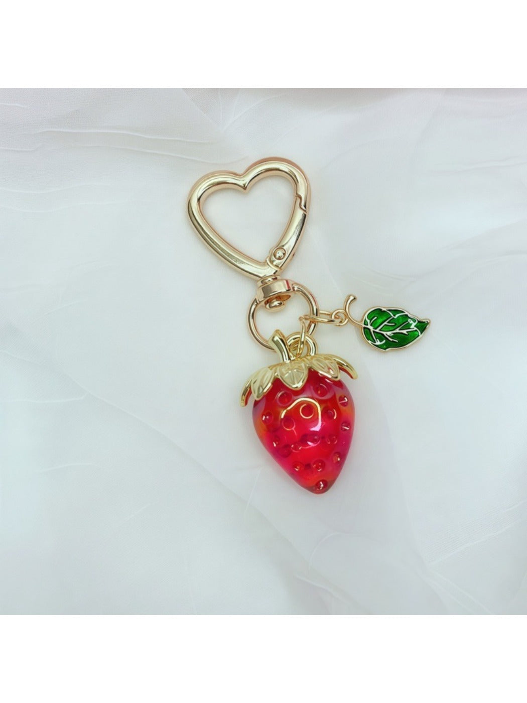 Multiple Keypus strawberry charm keychains arranged in a row on white surface