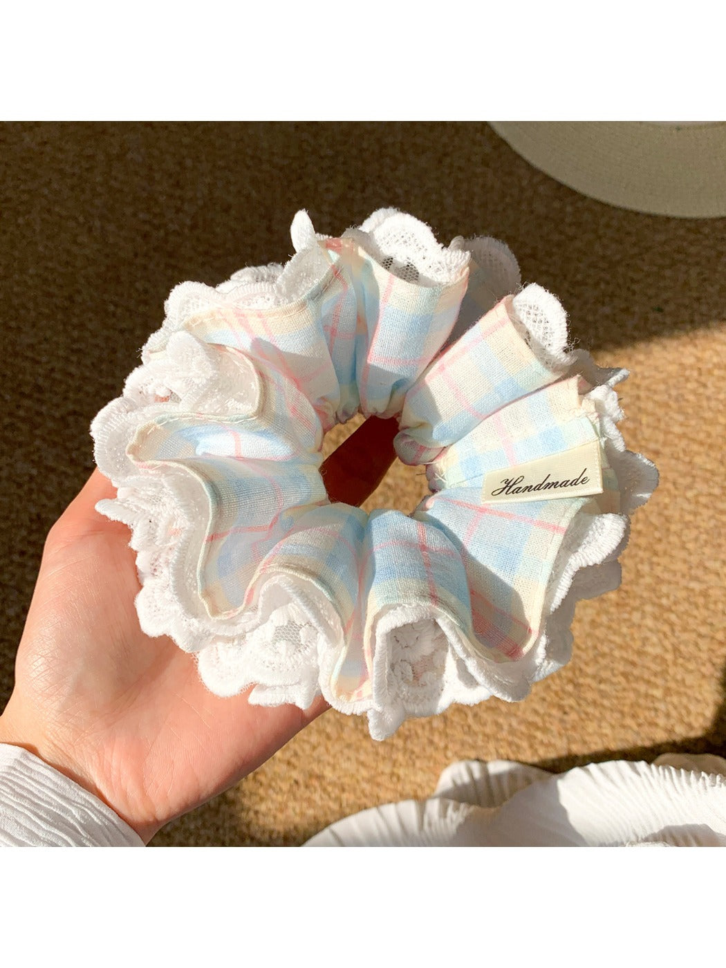 Blue plaid scrunchie with delicate white lace trim on a white background