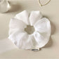 Ruched scrunchie stretched to show elasticity and fabric texture
