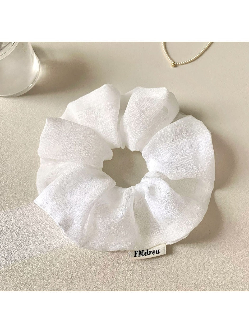 Ruched scrunchie stretched to show elasticity and fabric texture