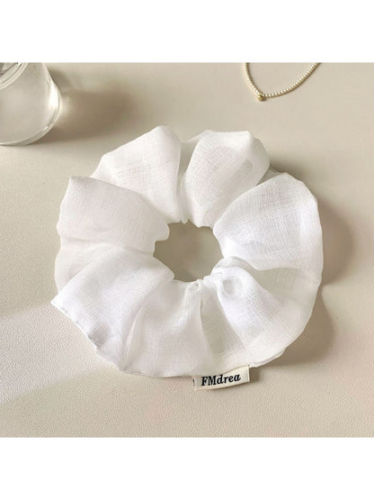 Ruched scrunchie stretched to show elasticity and fabric texture