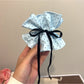 Gifty polka dot bow scrunchie paired with casual outfit accessories on a flat lay