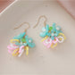 Top view of small colorful beaded flower cluster earrings highlighting intricate pattern