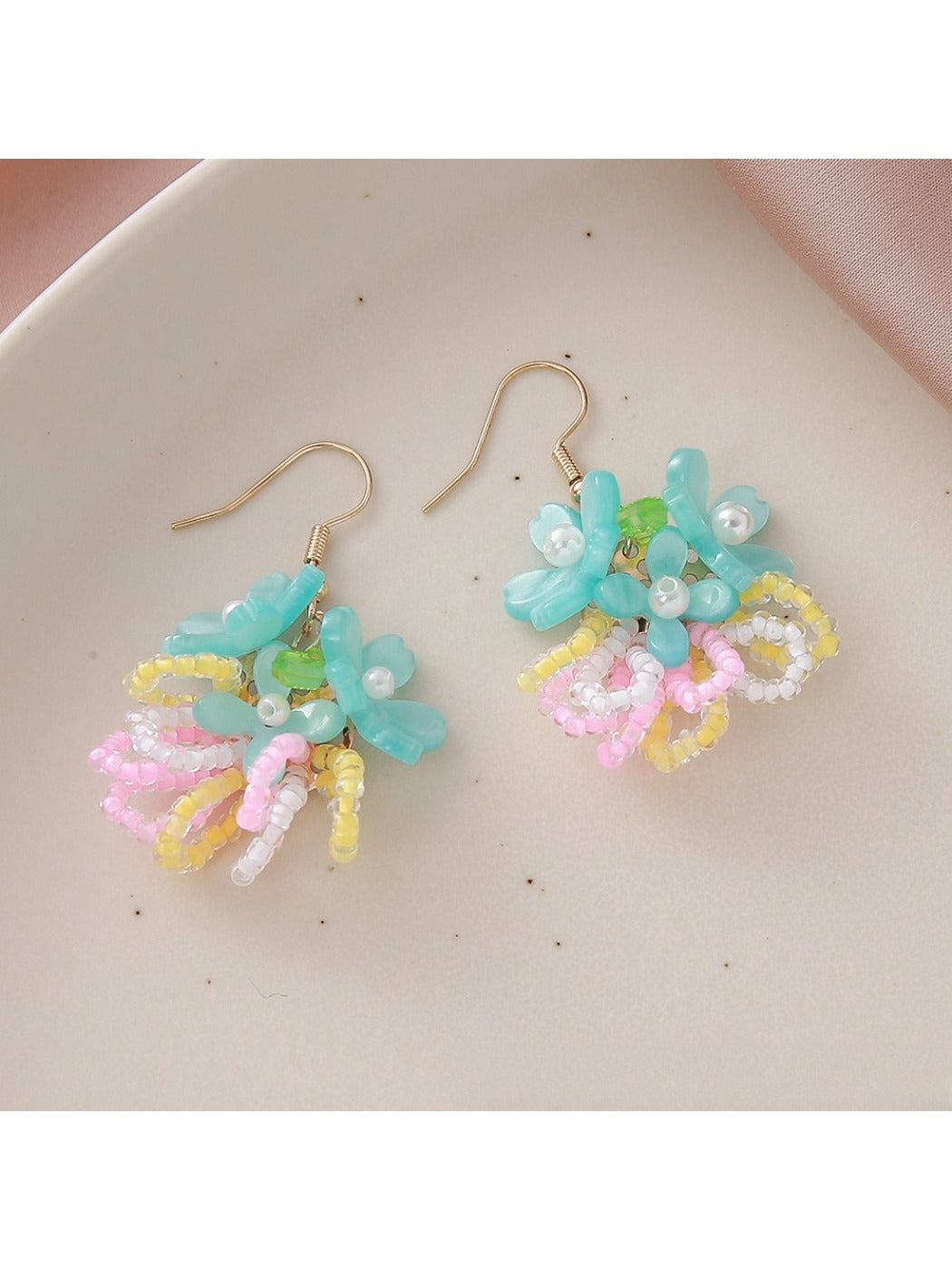 Top view of small colorful beaded flower cluster earrings highlighting intricate pattern