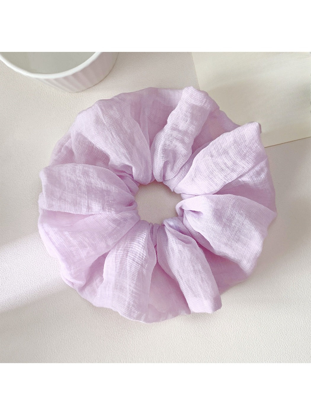 Scrunchie displayed on a white background highlighting its colorful pattern