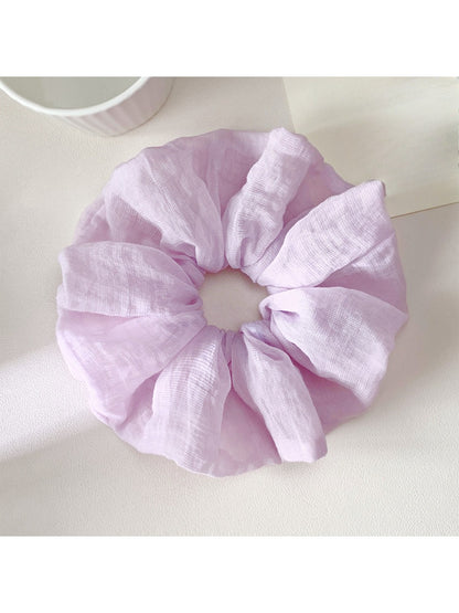 Scrunchie displayed on a white background highlighting its colorful pattern
