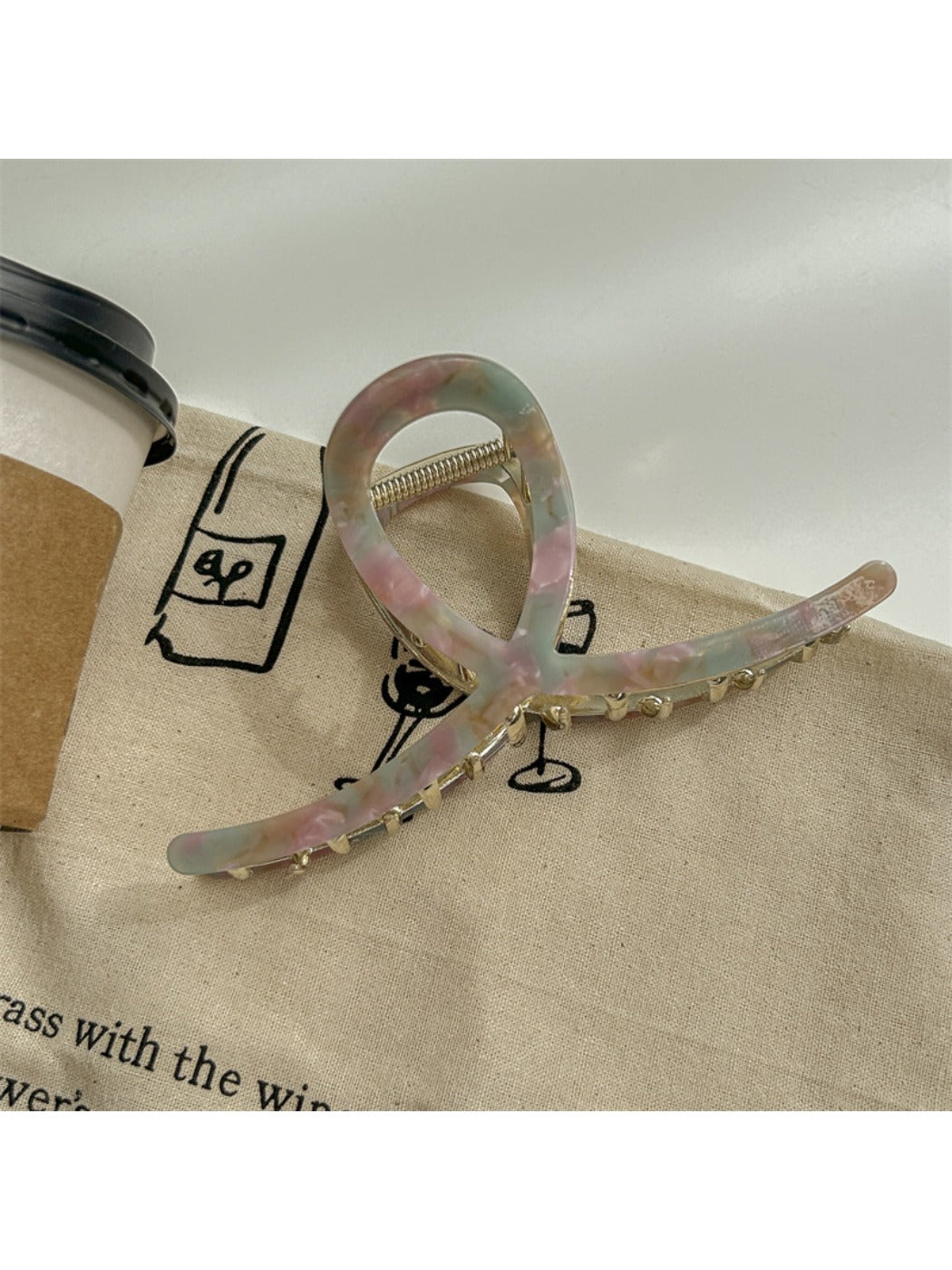 Beau large acetate claw clip resting on a wooden surface with natural light