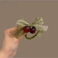 Green lace bow hair tie with intricate floral pattern on elastic band