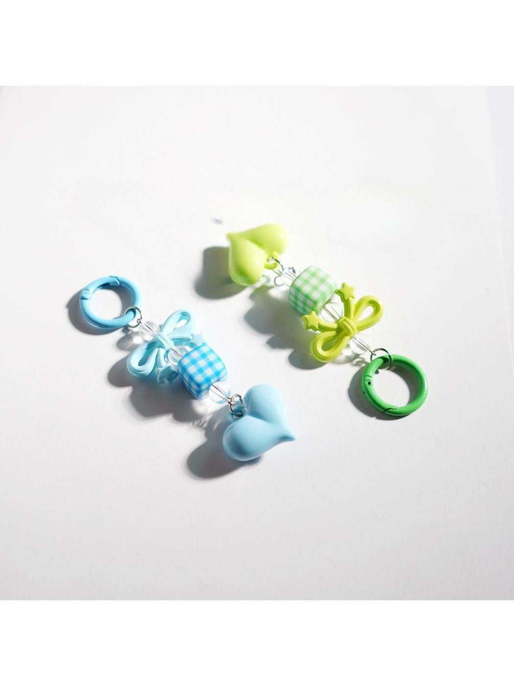 Keypus keychain featuring a pink bow and heart-shaped beads on a white background