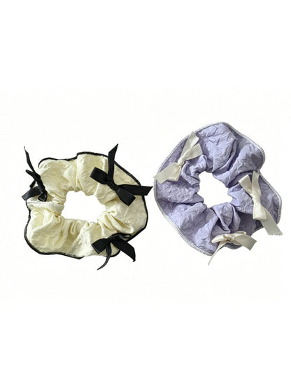 Gifty scrunchie with red ribbon bow styled in a ponytail on a model