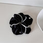Gifty satin scrunchie holding a ponytail in shiny, smooth fabric