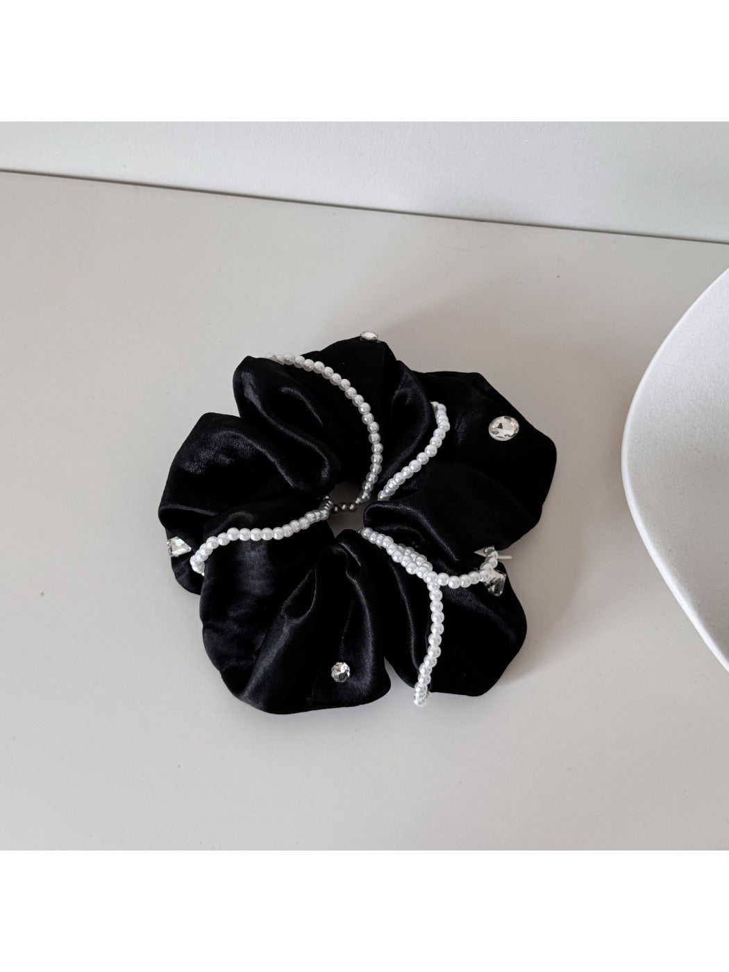 Gifty satin scrunchie holding a ponytail in shiny, smooth fabric