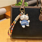 Silver cat charm keychain shown with a close-up of the keyring attachment