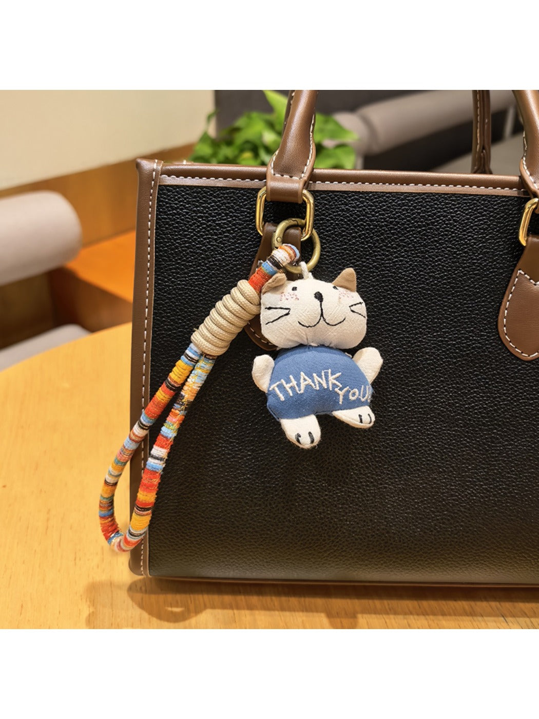 Silver cat charm keychain shown with a close-up of the keyring attachment