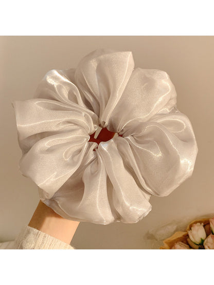 Multiple Gifty shiny scrunchies in different colors arranged in a circle