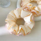 Pink ruffle beige scrunchie worn on a model's wrist
