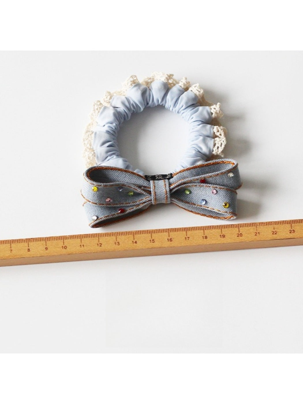 Multiple bow hair ties in pastel colors displayed on a textured fabric