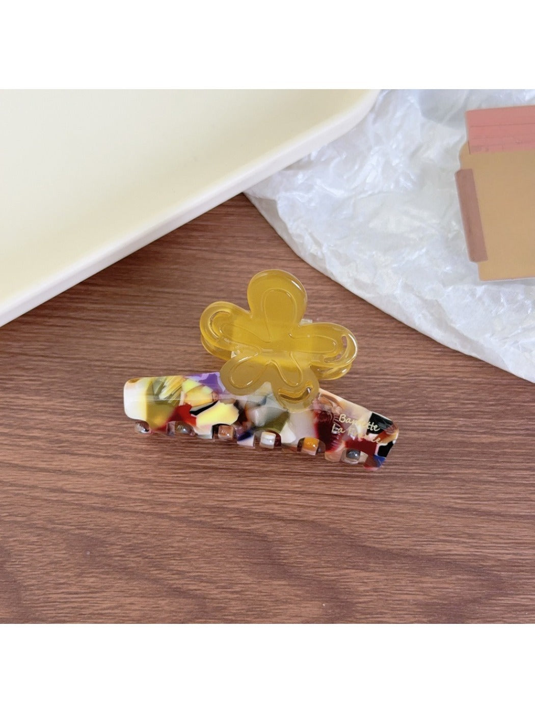 Beau claw clip placed on a wooden surface with natural lighting