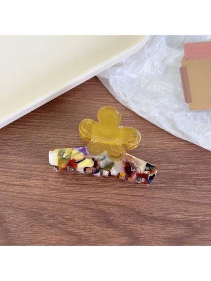 Beau claw clip placed on a wooden surface with natural lighting