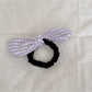 Gifty plaid hair tie with red bow embellishment styled in a casual hairdo