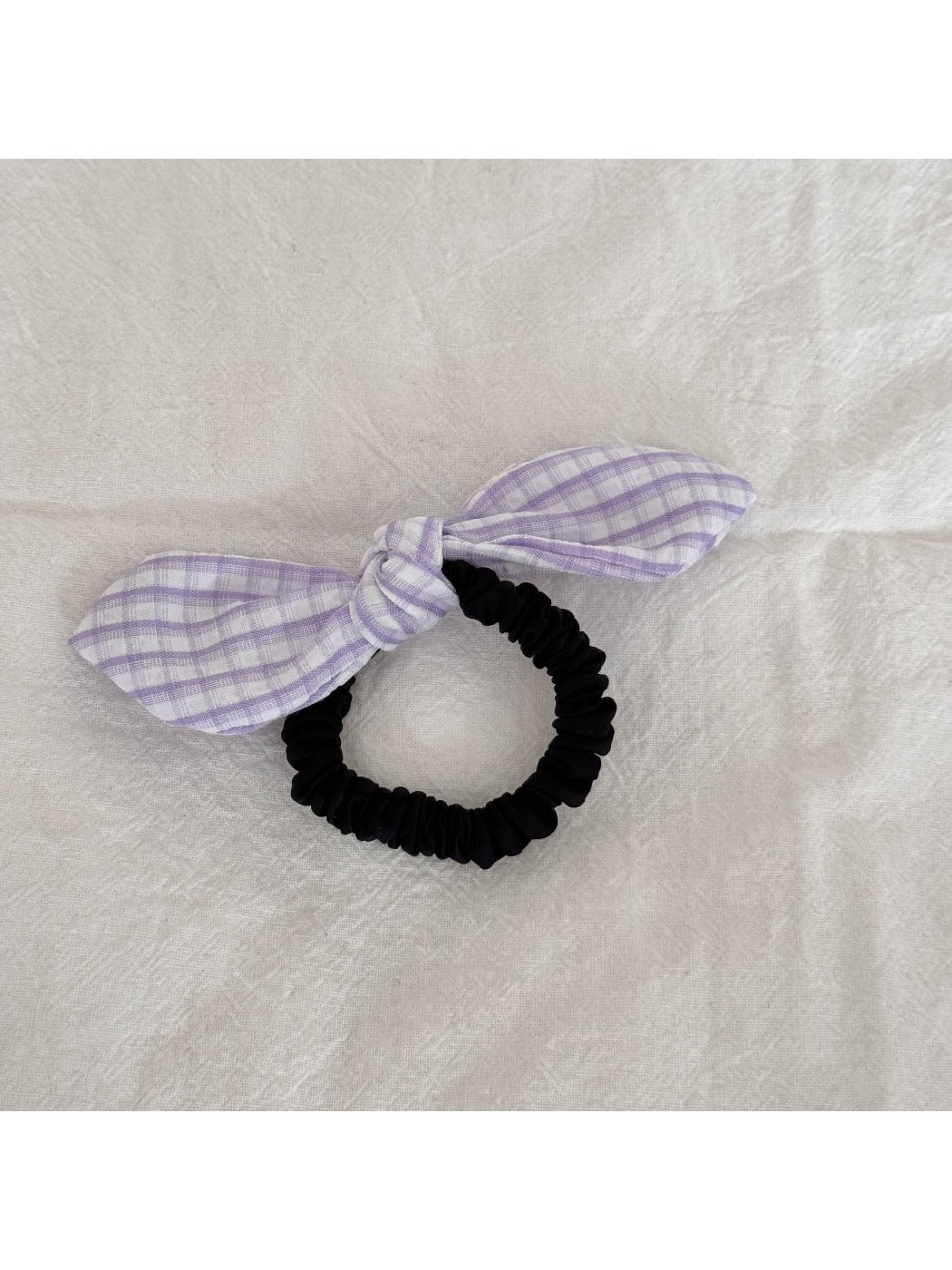 Gifty plaid hair tie with red bow embellishment styled in a casual hairdo