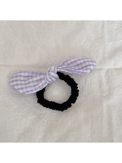Gifty plaid hair tie with red bow embellishment styled in a casual hairdo