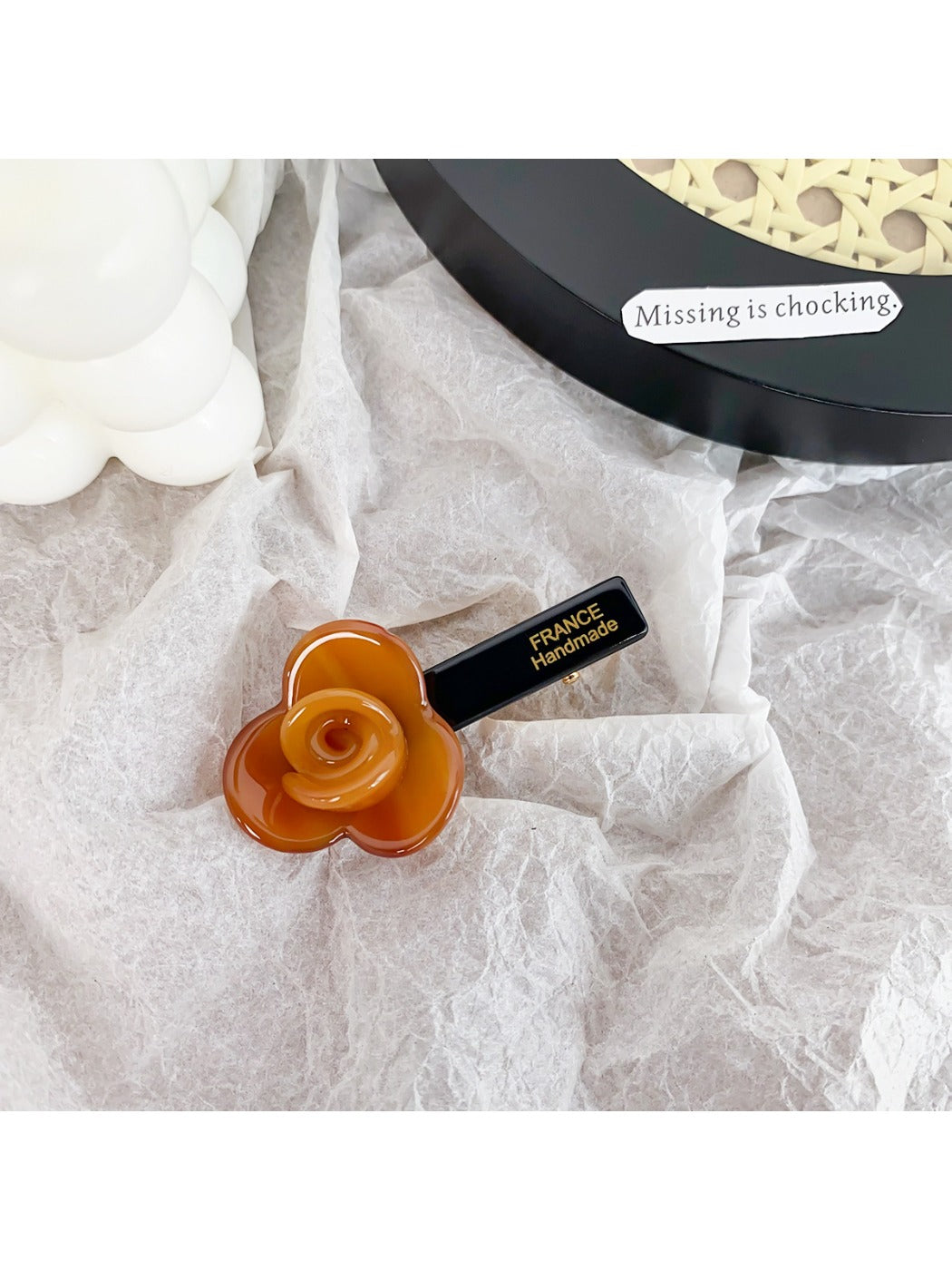 Beau hair clip placed on a wooden surface with soft natural lighting
