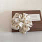 Gifty floral print scrunchie displayed with matching accessories on wooden surface