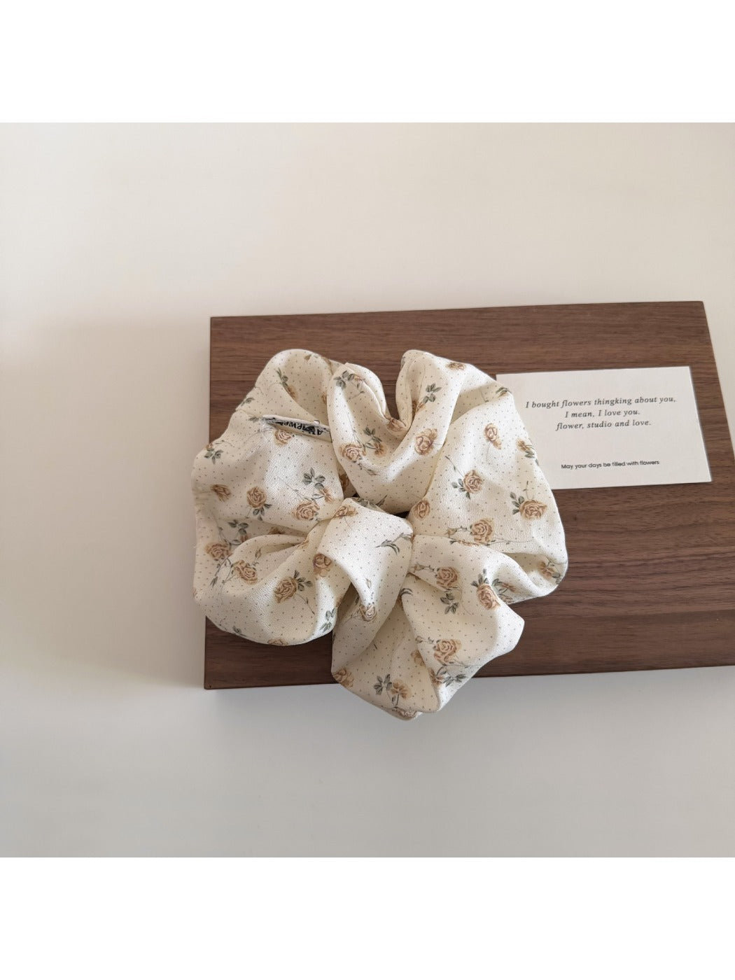 Gifty floral print scrunchie displayed with matching accessories on wooden surface