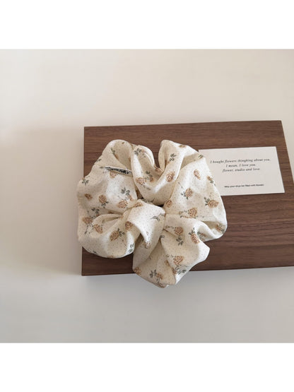 Gifty floral print scrunchie displayed with matching accessories on wooden surface