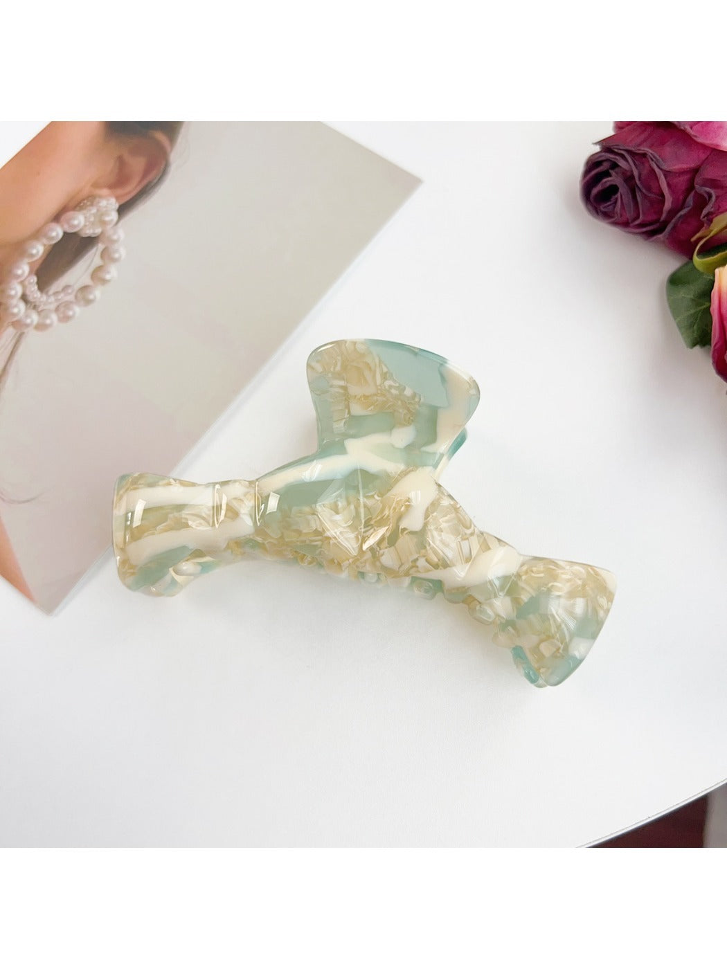Beau bow shaped claw clip holding a bun hairstyle from the back