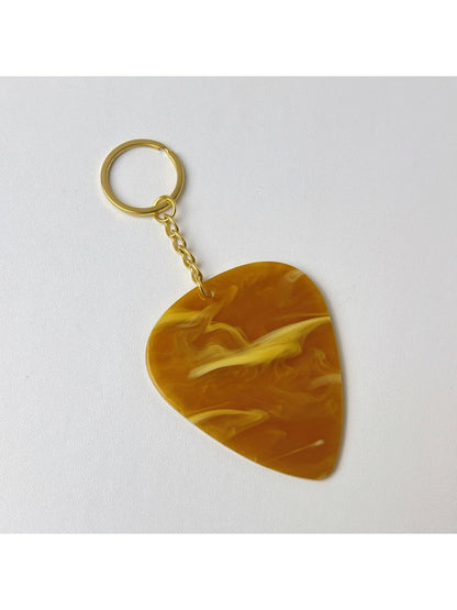 Hand holding the Keypus textured teardrop charm keychain against a blurred background