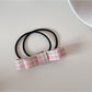 Close-up of the bow fabric texture and stitching on the hair tie