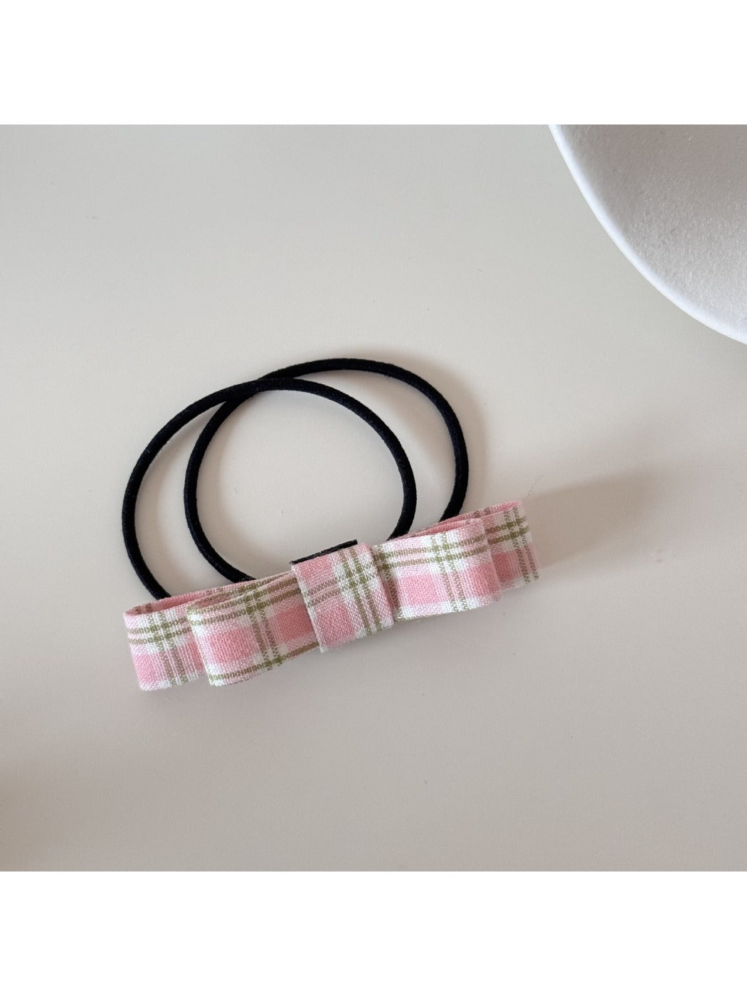 Close-up of the bow fabric texture and stitching on the hair tie