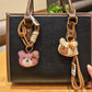 Bear charm keychain attached to a set of keys on a wooden surface