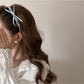 Side view of pink bow headband on a white background