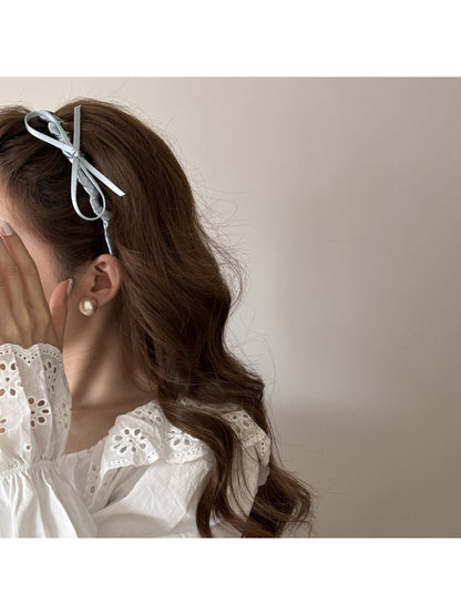 Side view of pink bow headband on a white background