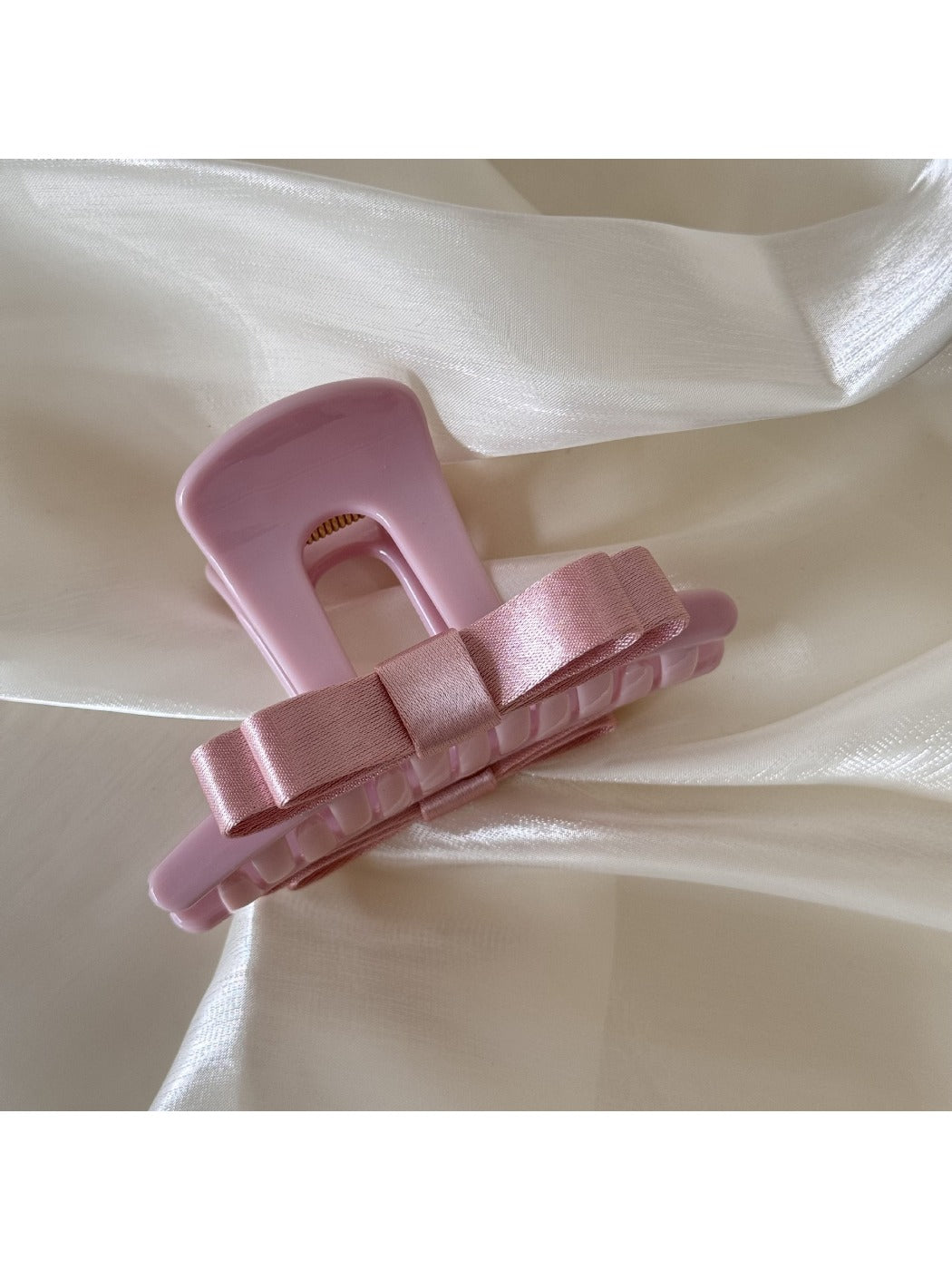 Beau T shaped bow hair claw clip displayed on a wooden surface