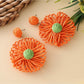Top view of raffia sunflower earrings highlighting detailed petal weaving