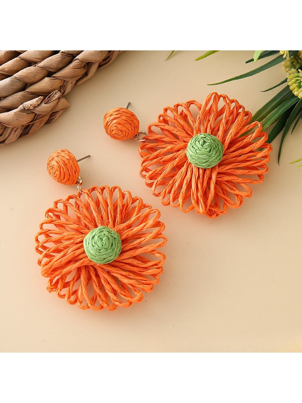 Top view of raffia sunflower earrings highlighting detailed petal weaving